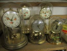 GROUP OF FIVE ANNIVERSARY CLOCKS WITH PAINTED DIALS, ALL WITH GLASS DOMES