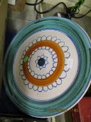 LARGE POOLE TYPE CHARGER WITH A CIRCULAR AND LOOPED DESIGN TO THE CENTRE WITHIN A GREEN WASH BORDER,