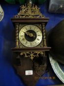 VIENNA OR DUTCH STYLE WALL CLOCK WITH SILVERED DIAL WITH ROMAN NUMERALS AND CARVED METAL FIGURES