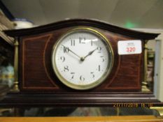 EDWARDIAN MANTEL CLOCK WITH BRASS PILLARS, WHITE ENAMEL DIAL AND FRENCH MOVEMENT, THE CLOCK RAISED