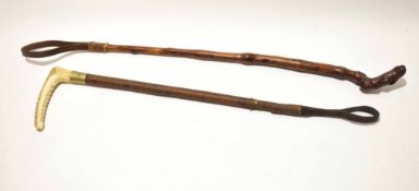 Two riding crops, one with wooden carved handle, the other with an ivory handle (2)