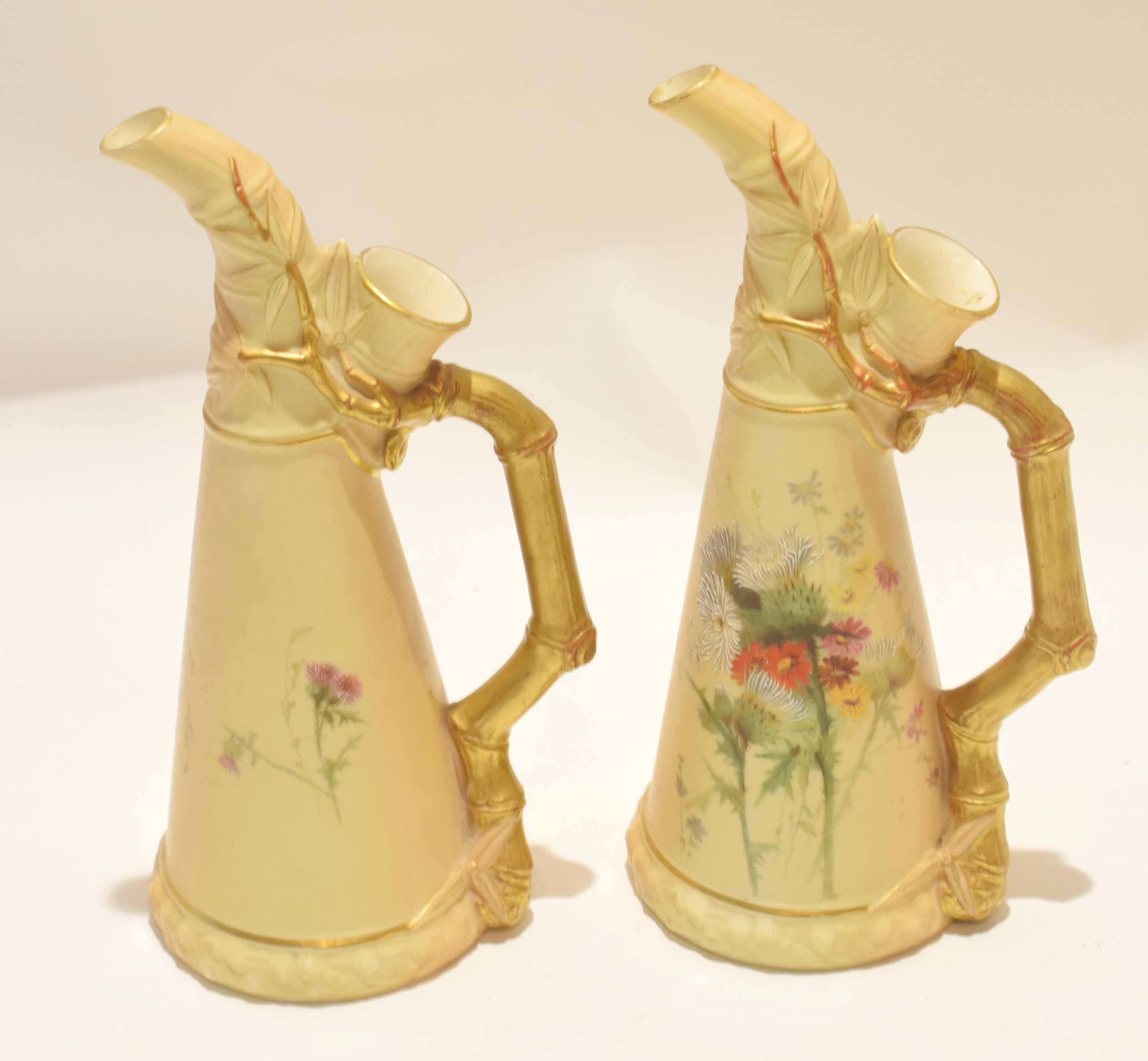 Pair of late 19th century Royal Worcester ewers, the blush ground decorated with flowers with gilt