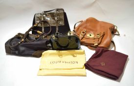 Bag containing an assortment of various handbags, one Prada Milano, a leather Mulberry bag, and