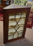 Mahogany wall mounted corner cupboard with astragal glazed doors enclosing fitted shaped shelving