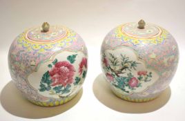 Pair of Chinese porcelain jars and covers with famille rose decoration within panels, surrounded