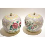 Pair of Chinese porcelain jars and covers with famille rose decoration within panels, surrounded