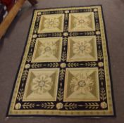 Modern Aubusson style carpet decorated with six floral panels on a black and mustard field, 177cm