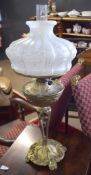 Victorian gilt metal oil lamp, the body moulded with foliage etc raised on scroll feet, 70cm high