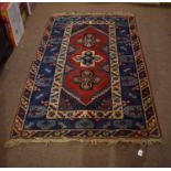 Modern Caucasian style wool carpet, three central cruciform lozenges, mainly red and blue field,