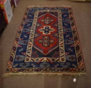 Modern Caucasian style wool carpet, three central cruciform lozenges, mainly red and blue field,