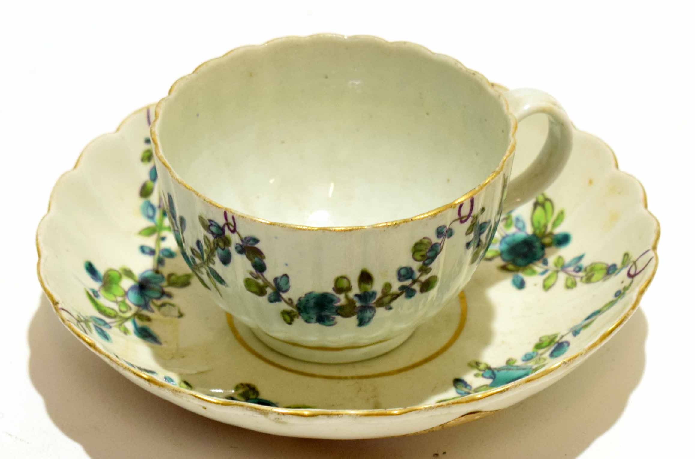 18th century Worcester porcelain cup and saucer decorated with swags of flowers in green enamel, the