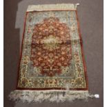 Modern Oriental small rug, central lozenge on a mainly rust and pale blue field, 125cm x 78cm