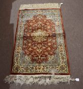 Modern Oriental small rug, central lozenge on a mainly rust and pale blue field, 125cm x 78cm