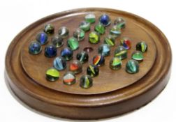 Circular solitaire board with collection of marbles