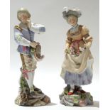 Continental porcelain model of a man and a lady on rockwork bases, 25cm high