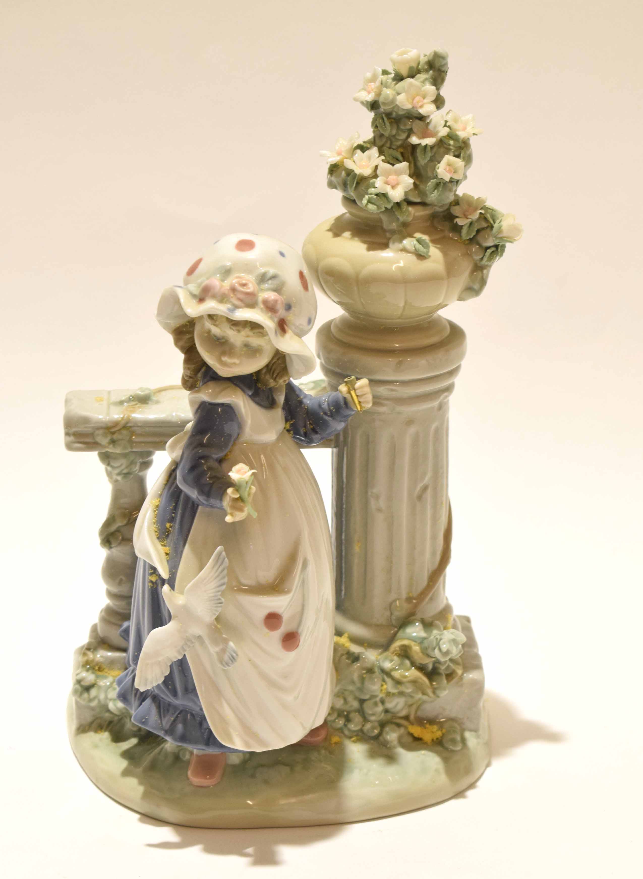 Lladro figure of a young girl alongside a classical column with floral spray, 30cm high