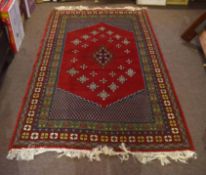 Modern Caucasian style carpet, central panel with geometric lozenge within four gull border, red,