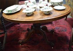 Victorian walnut loo table of oval form raised on moulded pedestal terminating in a quadruped