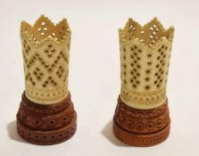 Two carved ivory spill holder vases or beaker containers on wooden bases, 9cm high