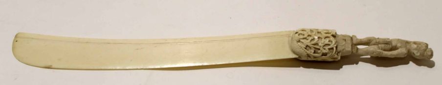 Large ivory model of a sword with carved hilt and man above, 36cm long