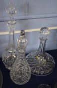 Three heavy cut glass decanters, one ship's decanter and two further baluster decanters with