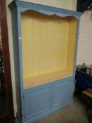 BLUE AND CREAM PAINTED OPEN FRONTED BOOKCASE WITH ADJUSTABLE SHELVES OVER TWO PANELLED CUPBOARD