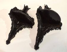 Pair of wooden corner brackets or shelves, with a scrolled design, stained black, 50cm long