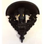 Anglo-Indian ebonised demi-lune shaped wall bracket, the support carved in the form of the head