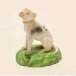 Late 18th century porcelain model of a hound on a green base, probably Derby, the animal sits on