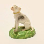 Late 18th century porcelain model of a hound on a green base, probably Derby, the animal sits on