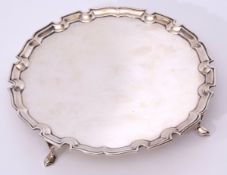 George V plain small silver waiter of circular form with "Chippendale" edge and supported on four