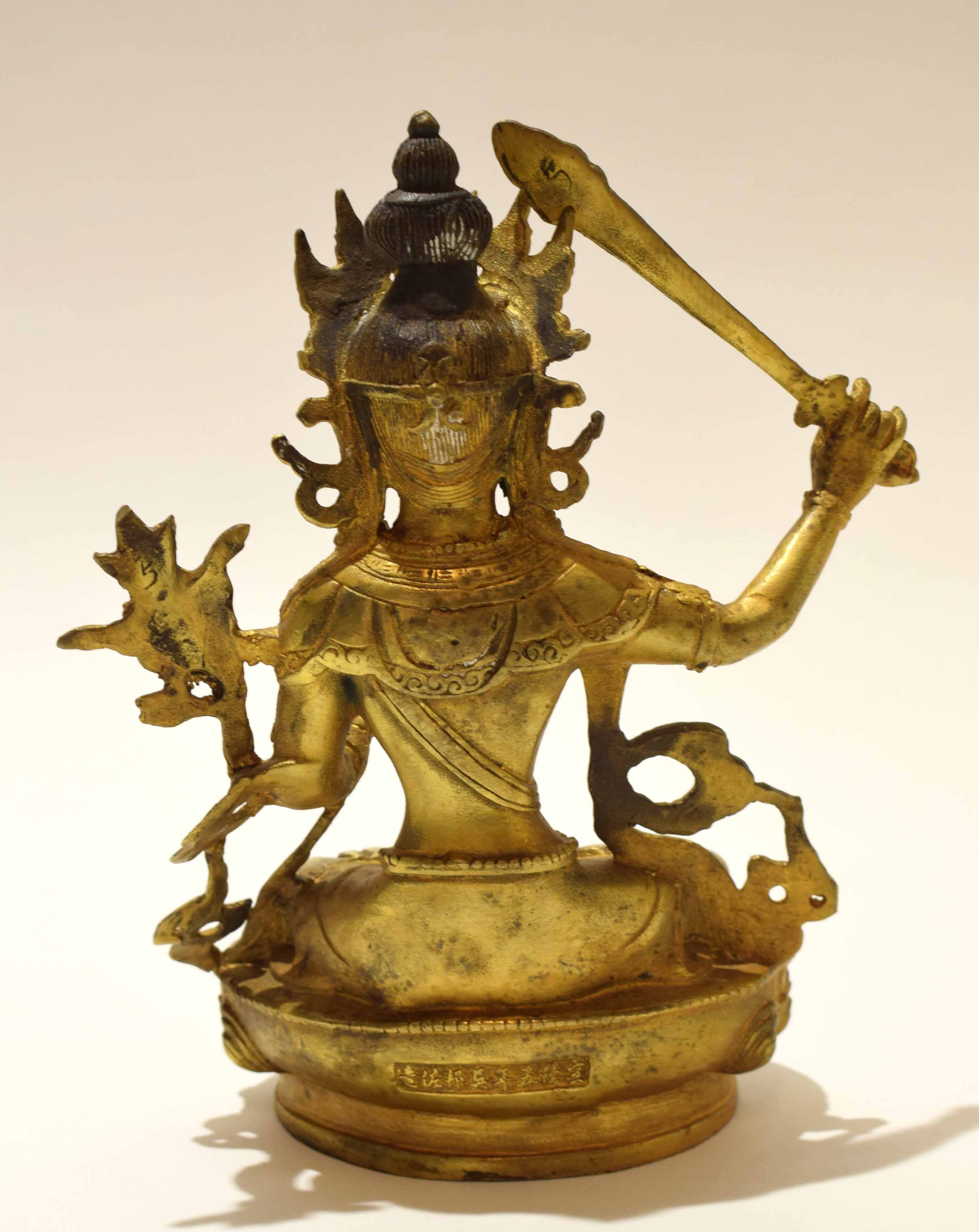 Gilt metal model of a Buddhistic deity in classic pose with inscription to rear, 21cm high - Image 3 of 8