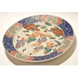 Late 19th century Japanese porcelain charger, decorated with figures at various pursuits within an