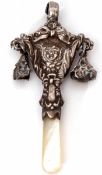 George V child's combination teether/rattle, the mask and ribbon embossed body (lacking teething