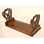 Early 20th century sliding book rack with carved ends, extending to 57cm