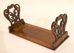 Early 20th century sliding book rack with carved ends, extending to 57cm