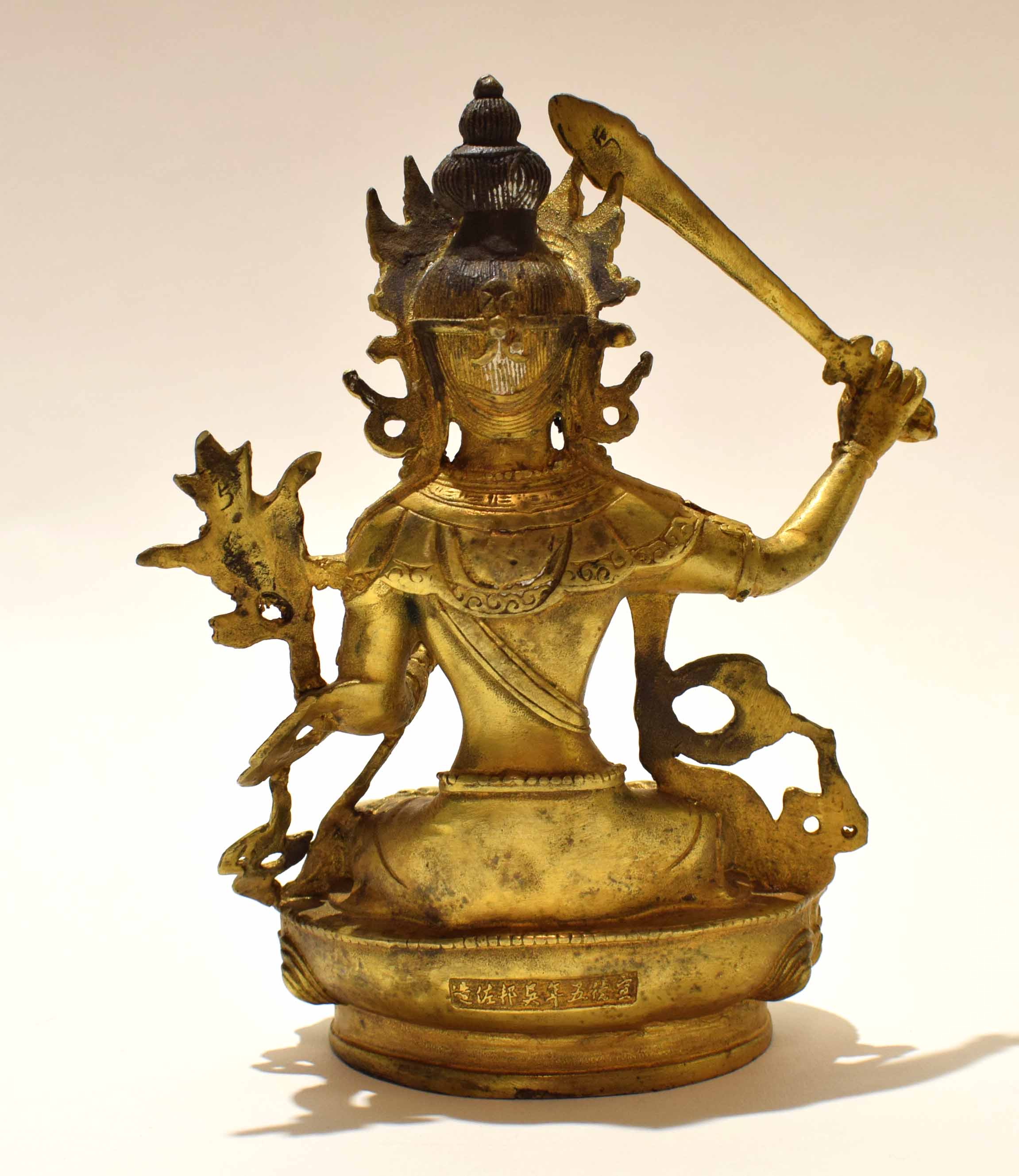 Gilt metal model of a Buddhistic deity in classic pose with inscription to rear, 21cm high - Image 5 of 8