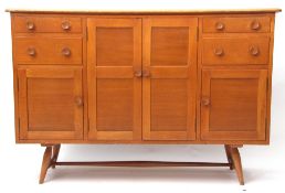 Mid 20th century Ercol blonde wood sideboard with four drawers and three cupboards supported by