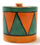 Clarice Cliff Bizarre jam pot and cover decorated with a geometric design in green and orange,