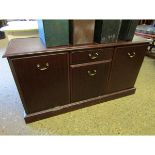 TEAK EFFECT SIDEBOARD FITTED CENTRALLY WITH A SINGLE DRAWER OVER A CUPBOARD DOOR FLANKED EITHER SIDE