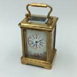 Brass cased miniature carriage clock with 8 day movement & porcelain panels, with key