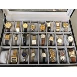 Collection of modern quartz watches in display case, to include a LCD digital gold plated