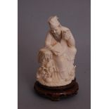 C19th Chinese ivory carving of a seated scholar, holding a wine cup in his left hand, wood stand,