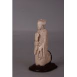 C19th Chinese ivory carving of a lady, standing and holding a fan in her right hand, wood stand.