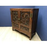 A Chinese Late C19th hardwood cabinet with carved figural panels, opening to reveal 2 drawers &