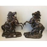 Pair of bronzes in the style of G Coustou of a man holding a rearing horse 42cm