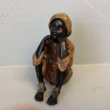 Cold painted bronze figure of a seated boy 6.5 cm