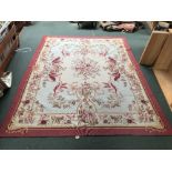 Small Aubbuson style rug with pink border surrounded with flora pattern on pale blue & cream