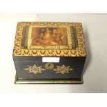 Small compartmented papier mache tea caddy decorated in gilt with a religious scene on the lid