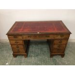 C19th mahogany twin pedestal writing desk of 9 drawers beneath a red tooled leather top